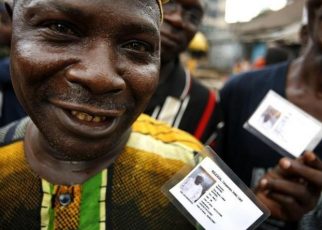 Nigerian voters show off their identity cards while lining up to vote in the neighbourhood of Isale-Eko in in a file photo. [REUTERS Finbarr O'Reilly]