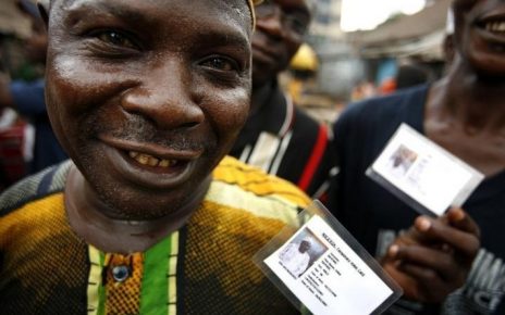 Nigerian voters show off their identity cards while lining up to vote in the neighbourhood of Isale-Eko in in a file photo. [REUTERS Finbarr O'Reilly]