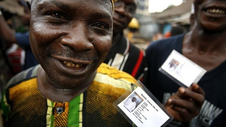 Nigerian voters show off their identity cards while lining up to vote in the neighbourhood of Isale-Eko in in a file photo. [REUTERS Finbarr O'Reilly]